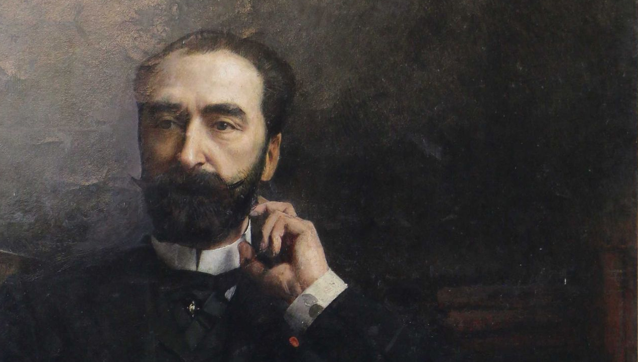 Portrait d'un homme avec une barbe, un costume sombre et un col blanc, touchant son visage