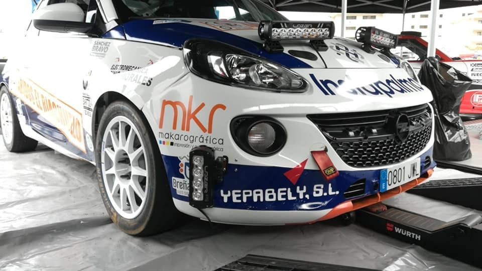 Un coche de carreras blanco y azul está aparcado en un garaje.