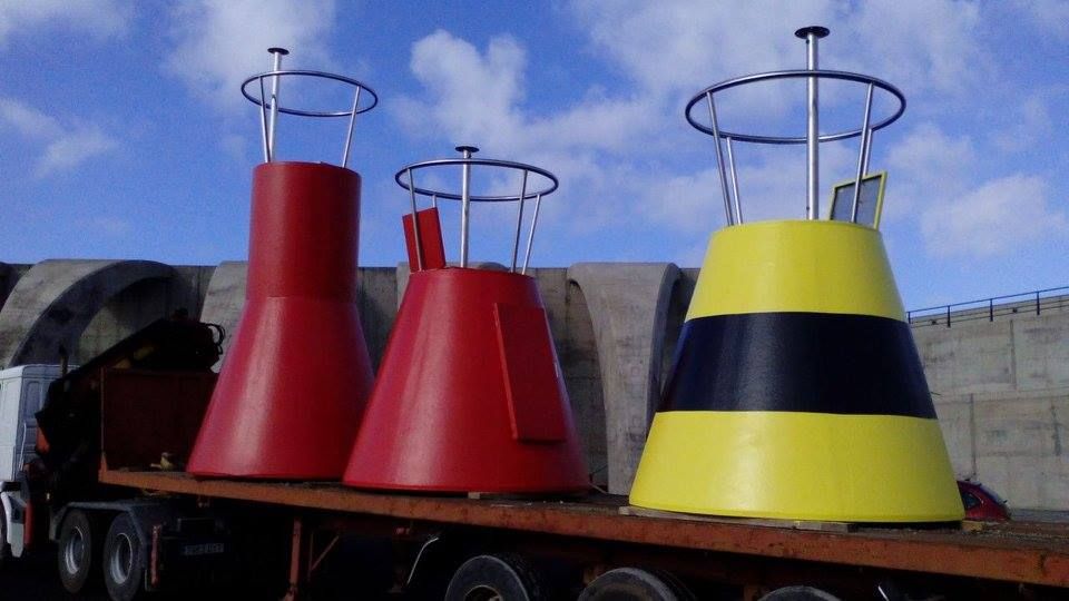 Tres boyas rojas y amarillas están sentadas en la parte superior de un camión.