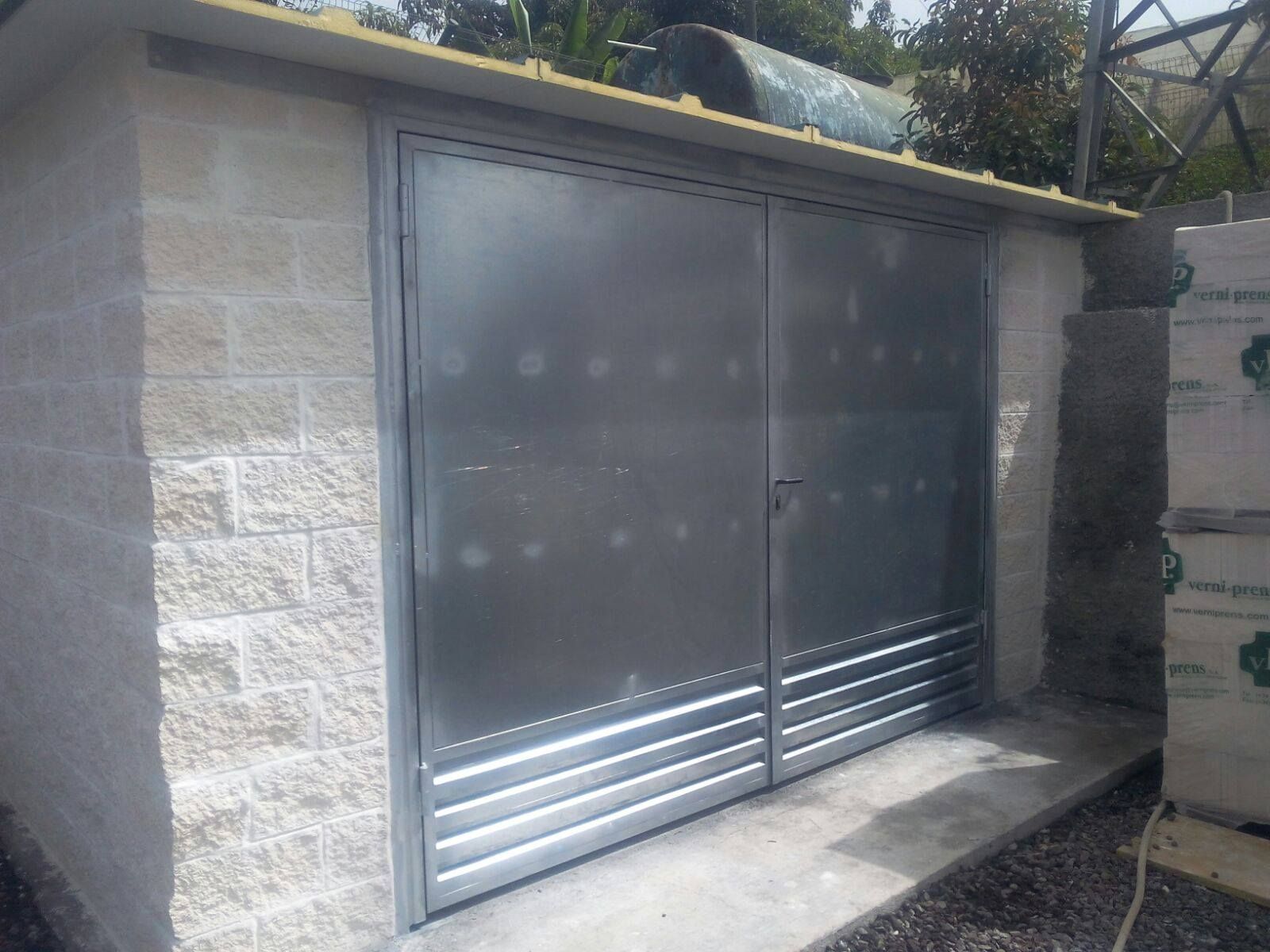 Un edificio de ladrillo con una puerta de metal y un techo