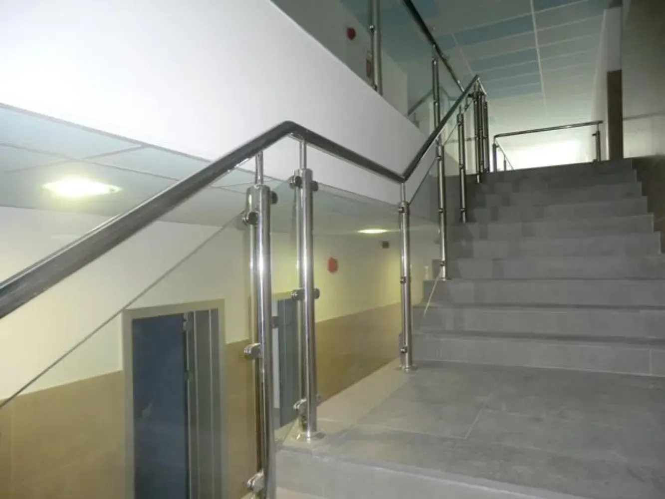 Una escalera con barandilla de cristal en un edificio