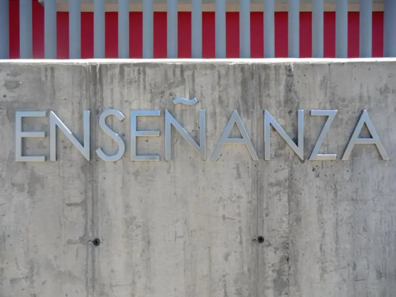 La palabra enseñanza está en un muro de concreto.