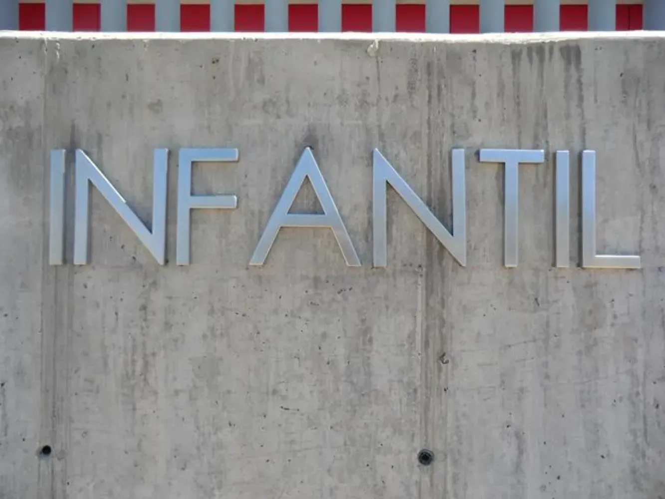 La palabra infantil está en una pared de hormigón.