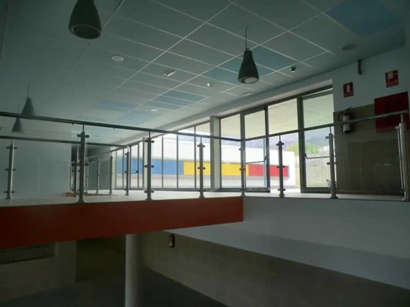 Un balcón en un edificio con barandilla de cristal.