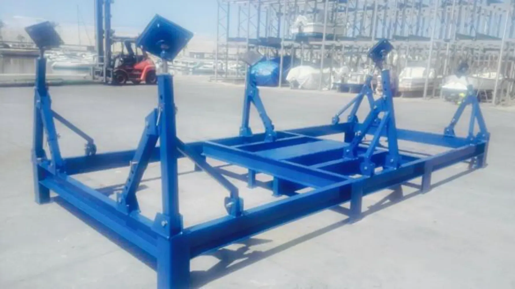 Una estructura de metal azul está sentada en el suelo en un estacionamiento.