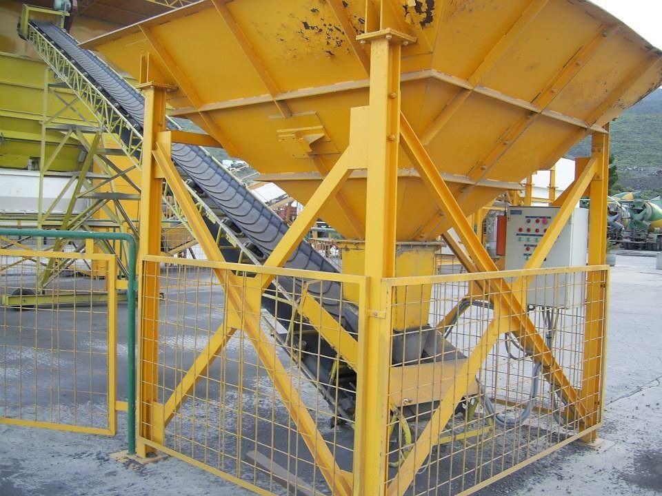 Una estructura metálica amarilla con escaleras y una cinta transportadora.