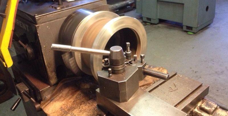 Una máquina está cortando un trozo de metal sobre una mesa.