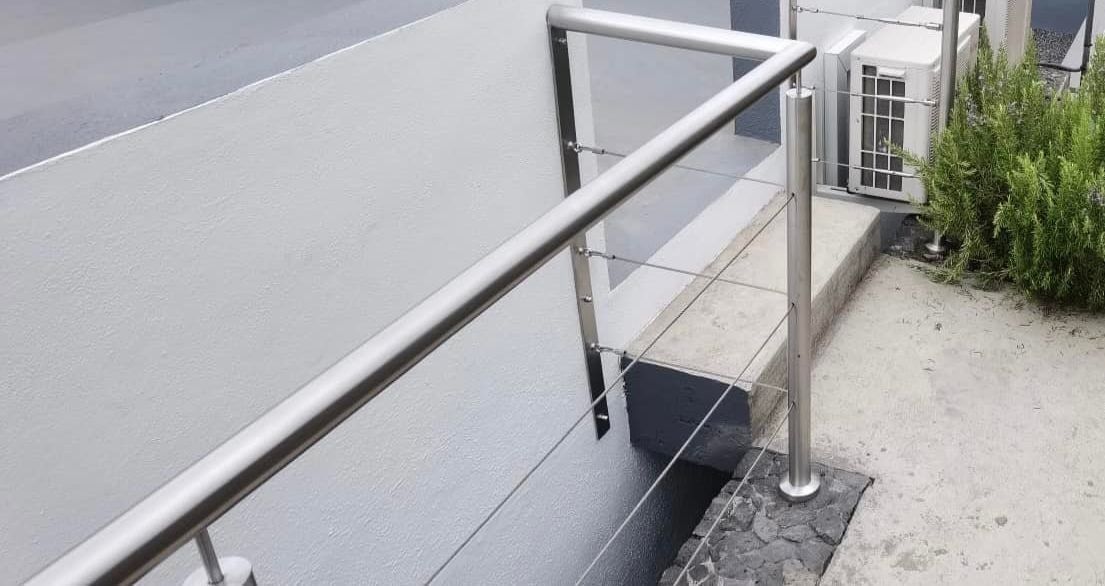 Una escalera con barandilla de acero inoxidable al lado de un edificio.
