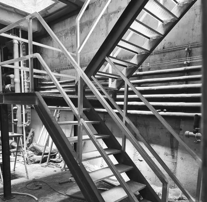 Una fotografía en blanco y negro de una escalera de metal