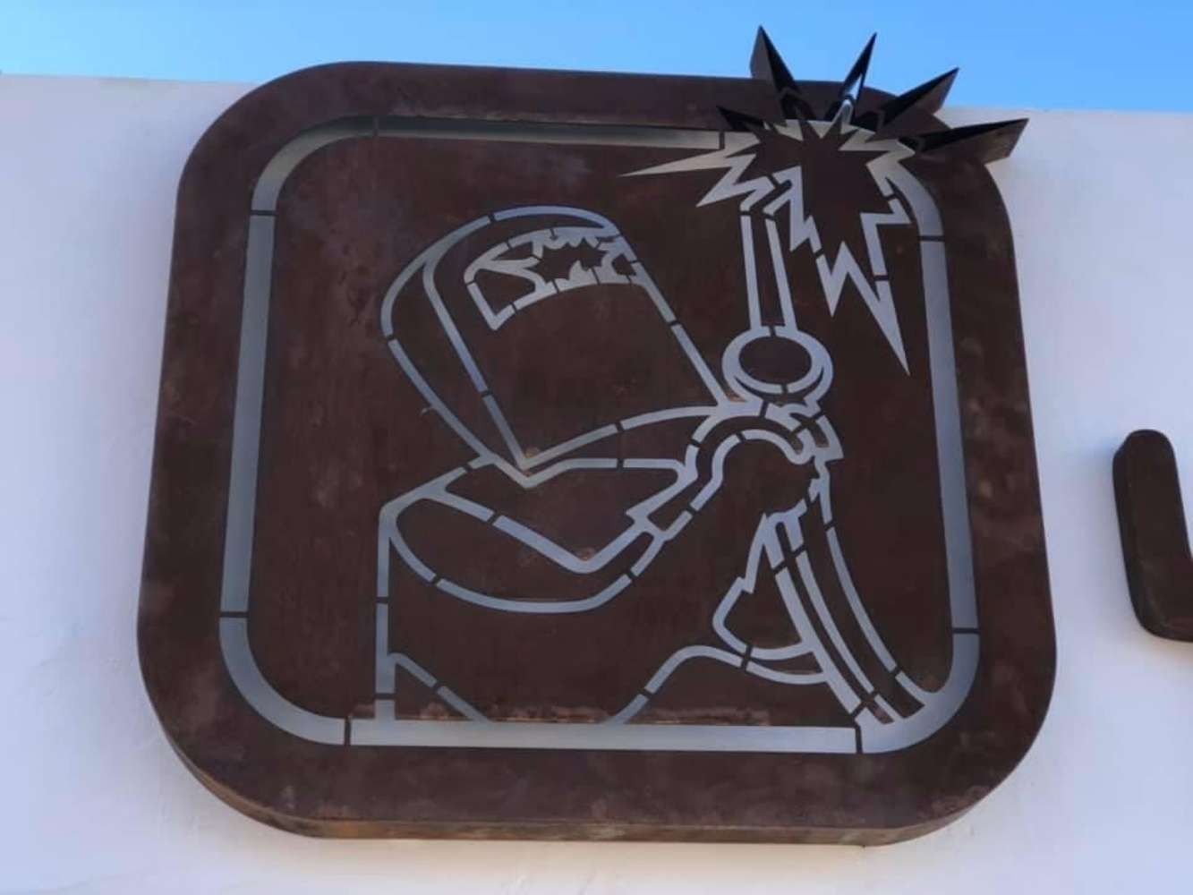 Un dibujo de un hombre soldando en una pared.