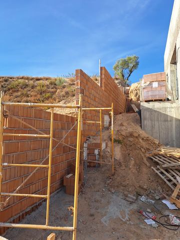 Se está construyendo un muro de ladrillos en la cima de una colina de tierra.