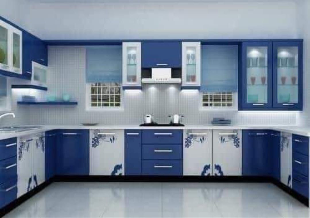 Una cocina con gabinetes azules y encimeras blancas.