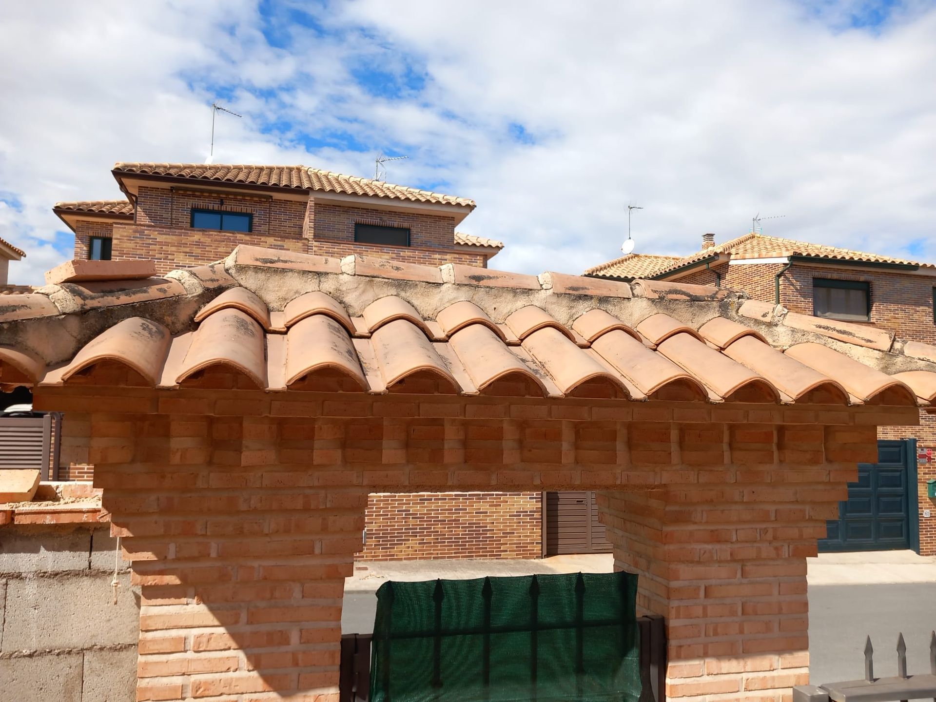 Un edificio de ladrillo con techo de tejas y una puerta.