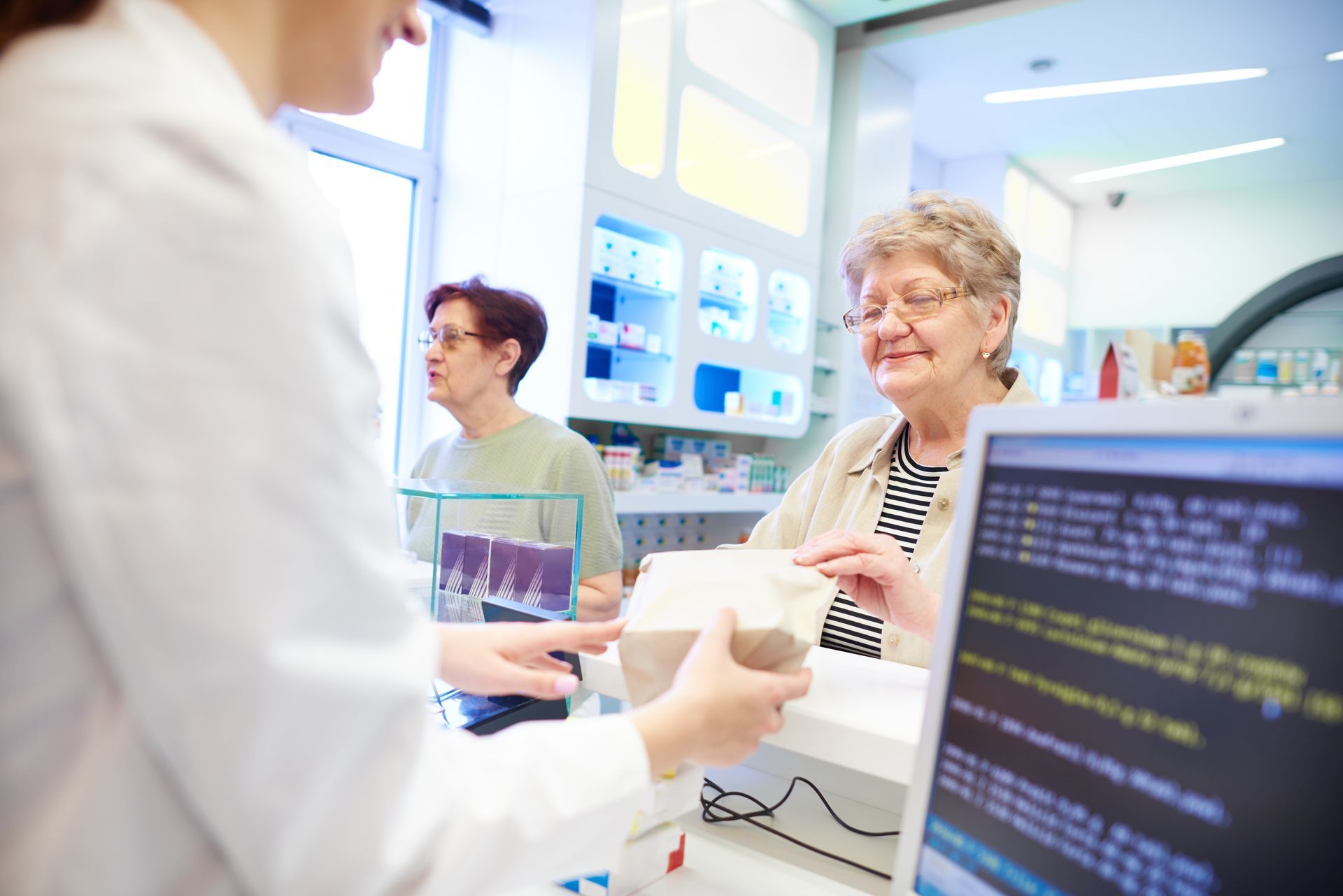Photo d'un pharmacien servant une personne âgée 