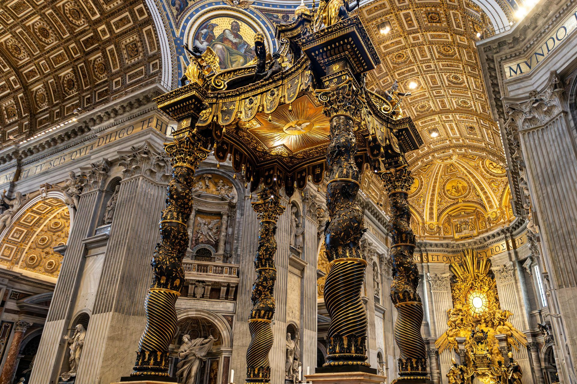 Ornate golden altar within a cathedral, featuring sculptures and intricate architectural details.