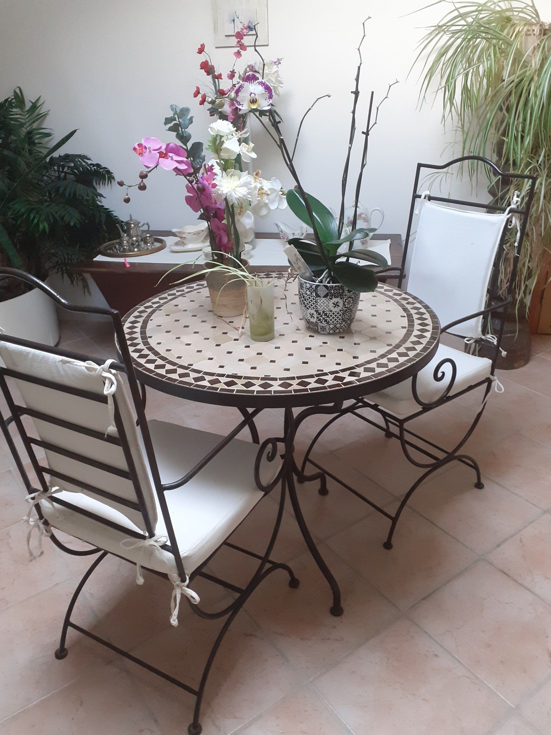 Chaises vintage assorties et deux fauteuils rayés contre un mur couvert de graffitis.