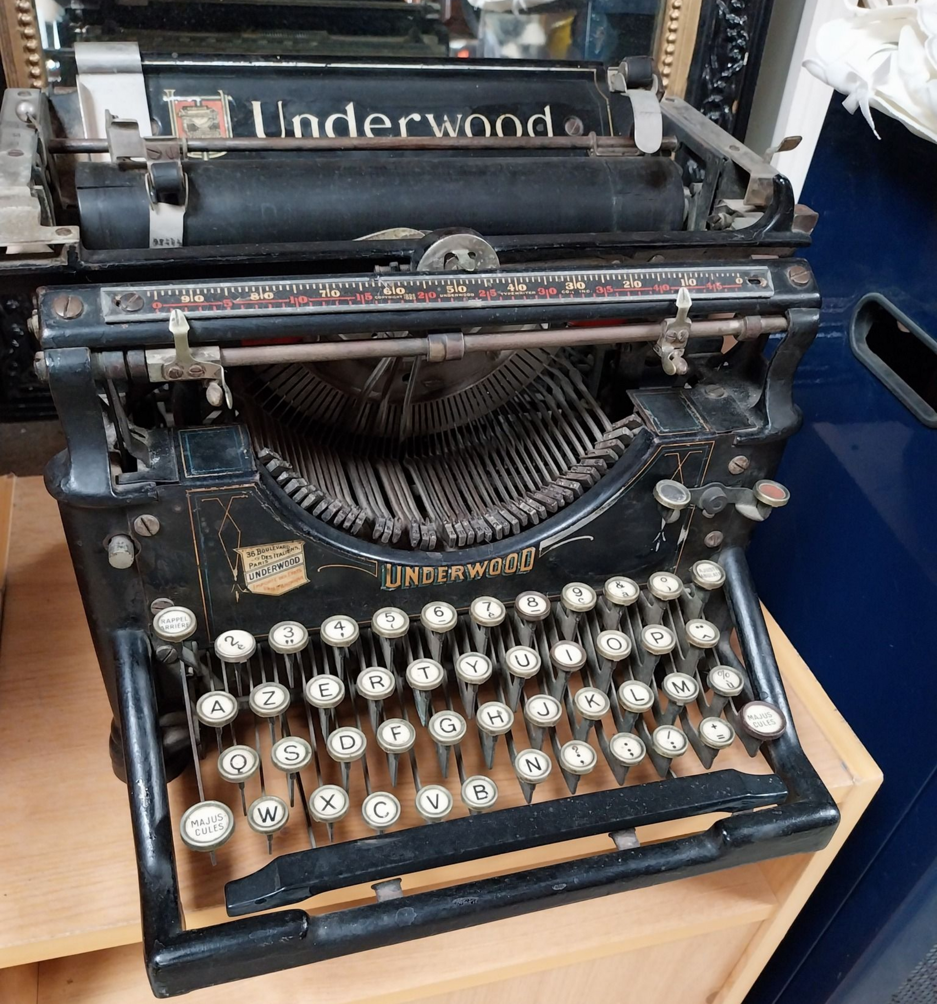 Machine à écrire Underwood noire vintage sur une surface en bois. Clavier à touches rondes.