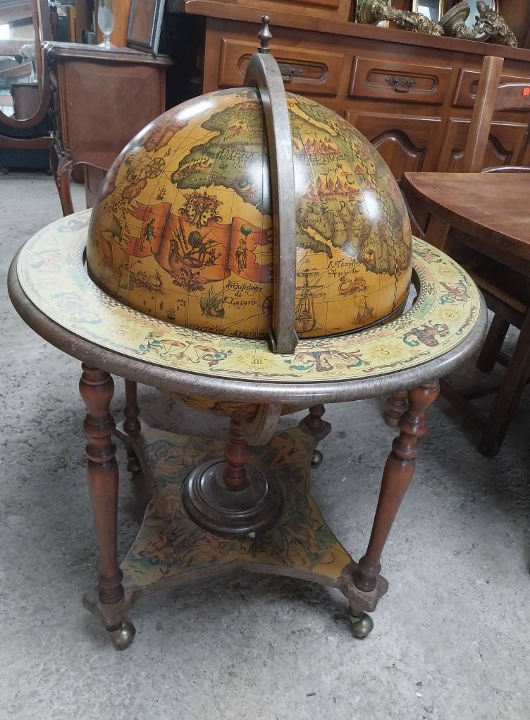 Globe terrestre ancien sur socle en bois avec base décorative, pour l'intérieur. Tons marron et beige.