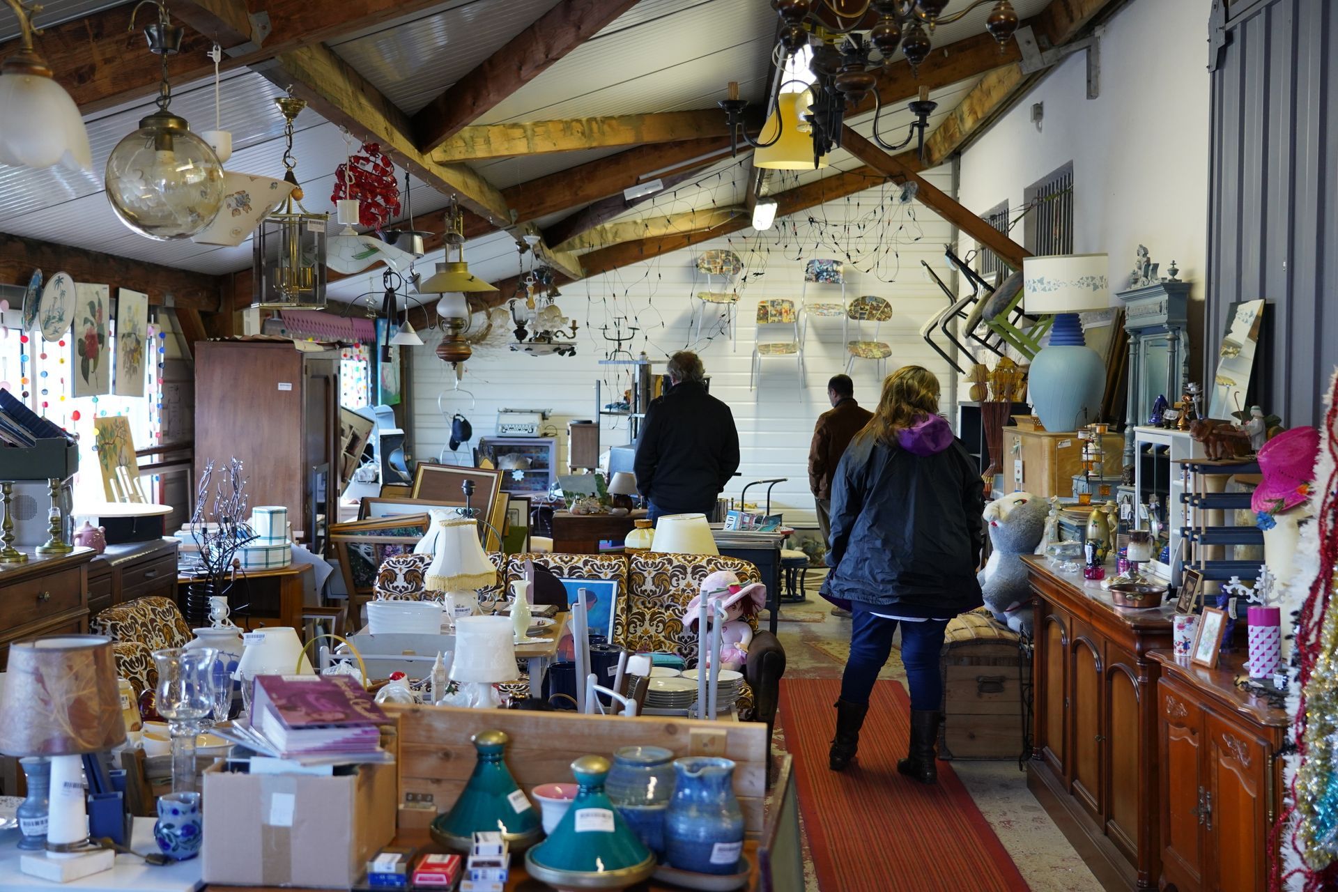 À l'intérieur d'une boutique encombrée remplie de meubles, d'antiquités et de gens qui chinent.