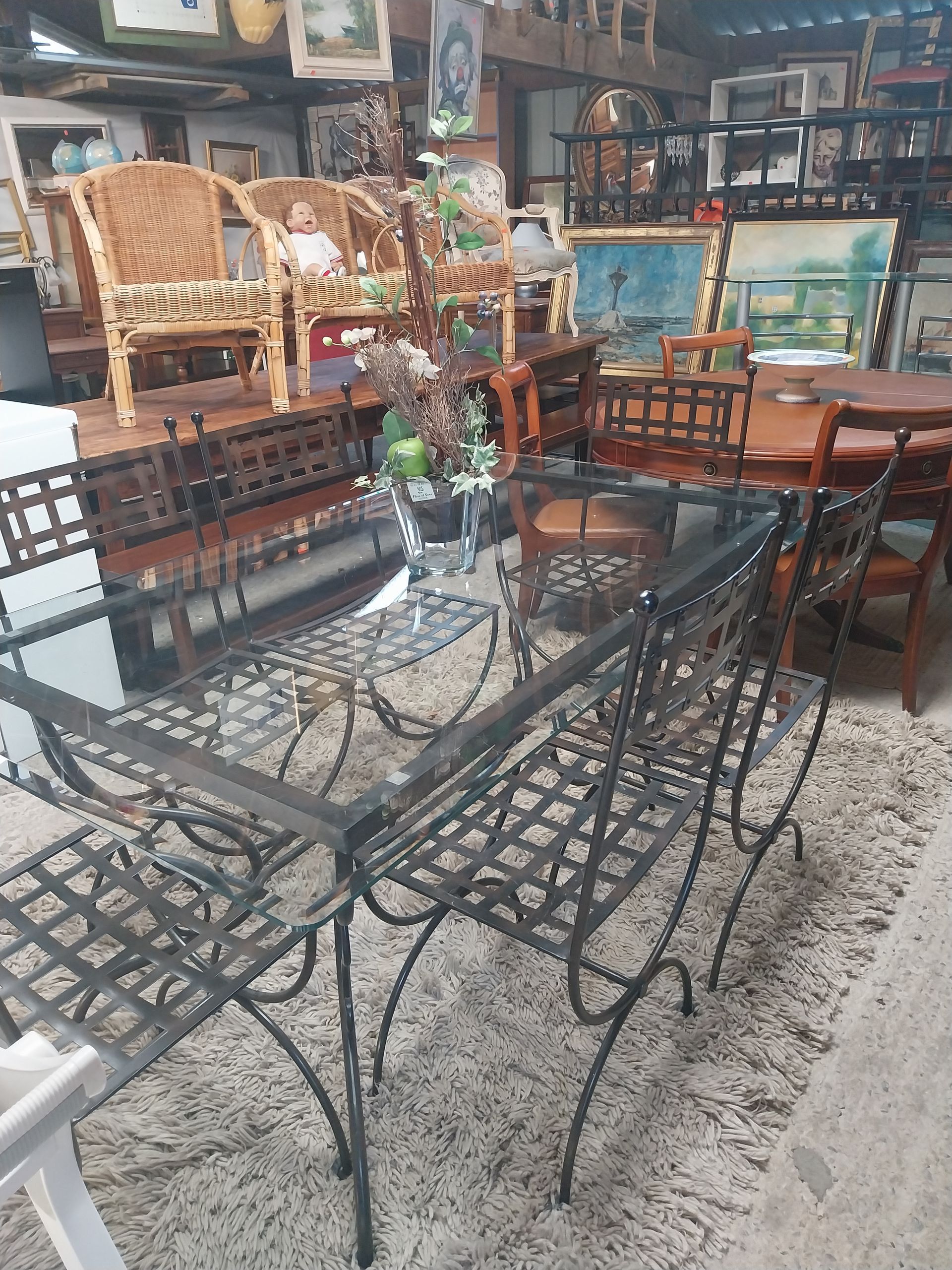 Atelier de menuiserie avec une scie à ruban, un bureau en bois et des chutes de bois éparpillées sur le sol.
