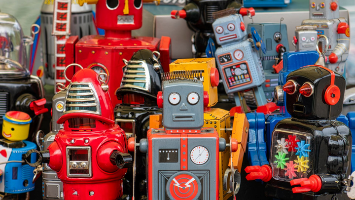 Une collection colorée de robots jouets vintage, chacun avec des formes, des couleurs et des caractéristiques distinctes.