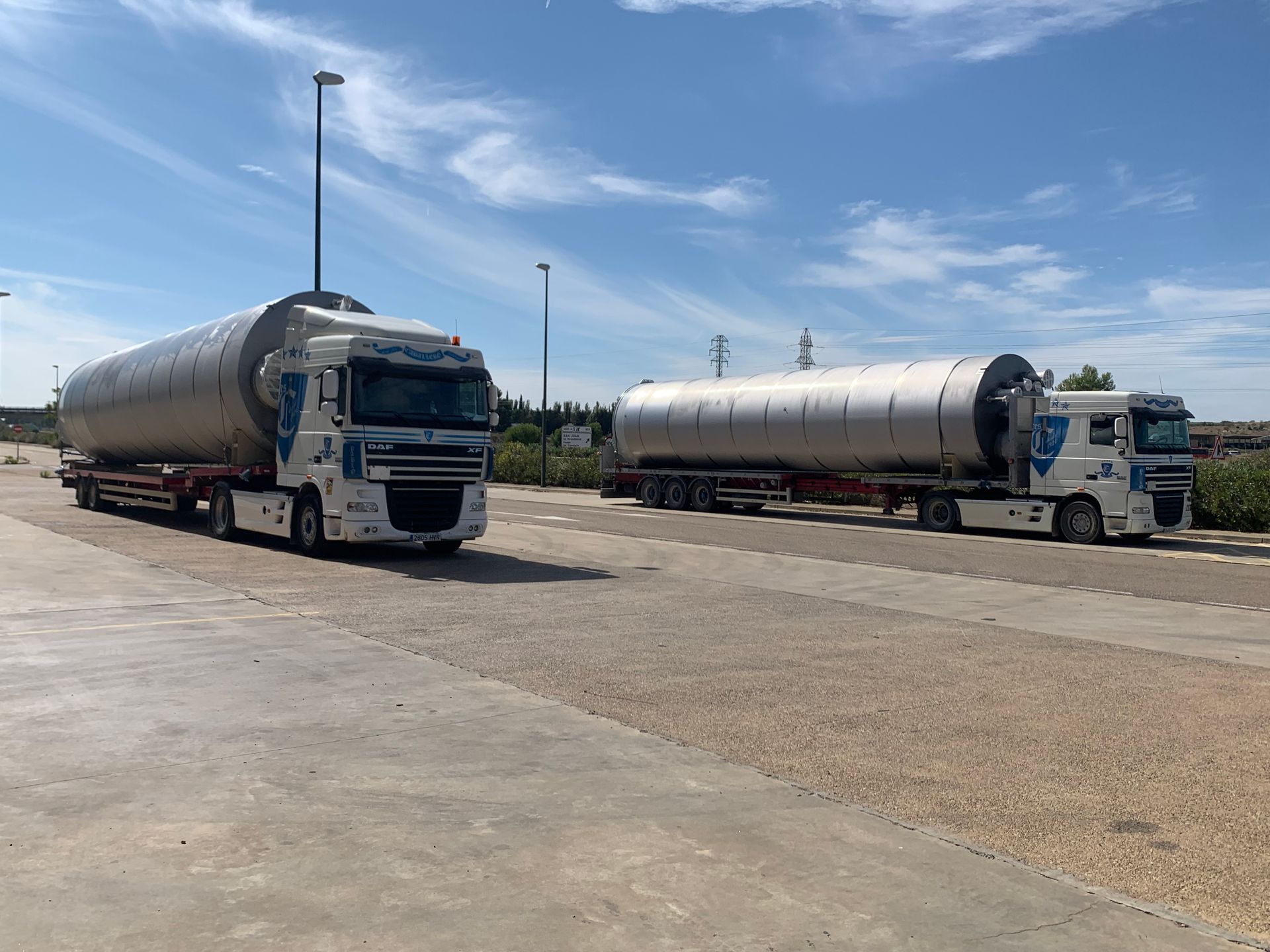 Dos camiones están estacionados uno al lado del otro en un camino de grava.