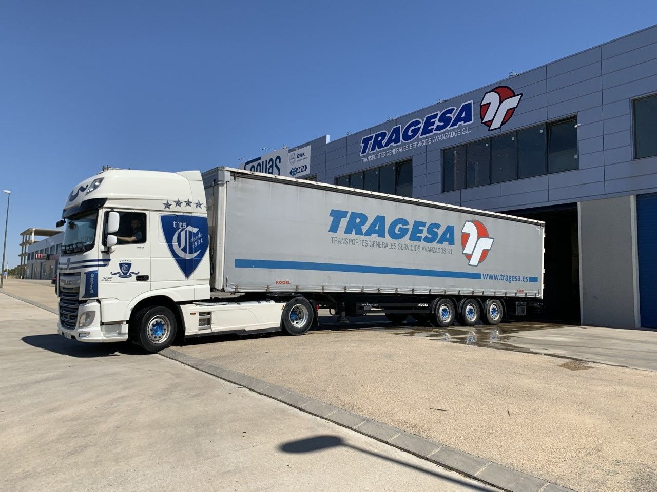 Un camión blanco está estacionado frente a un edificio que dice tragedia