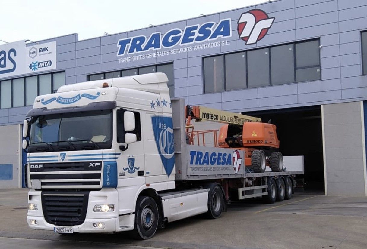 Un camión blanco está estacionado frente a un edificio que dice tragedia
