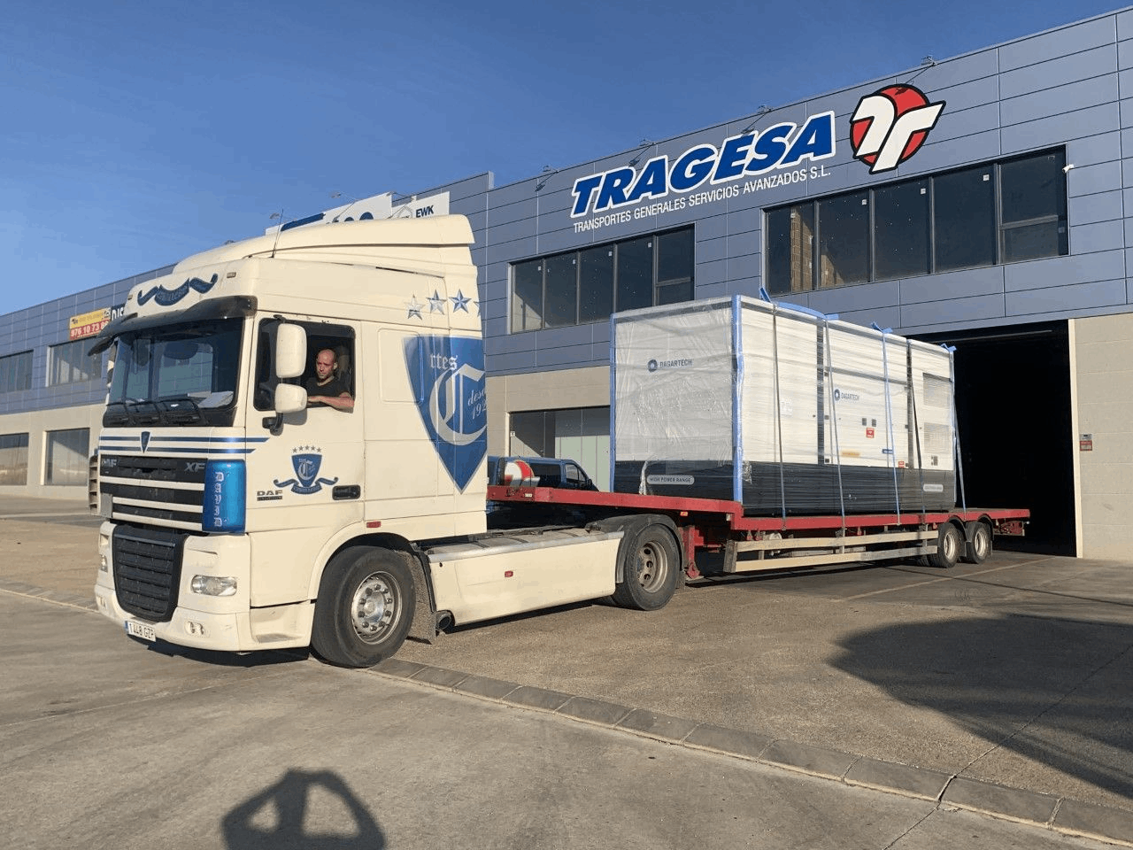 Un camión blanco está estacionado frente a un edificio.