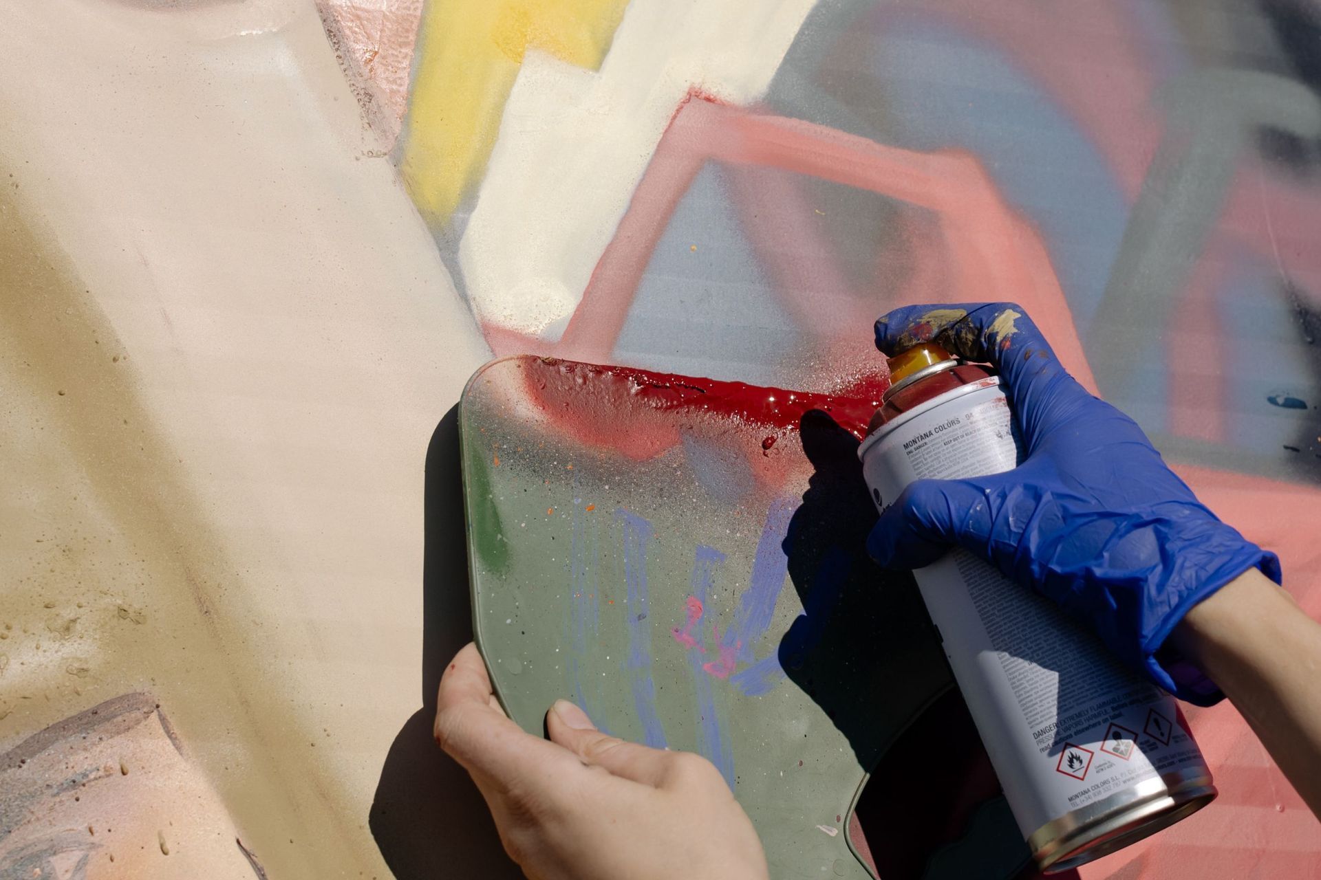 Una persona sostiene una lata de pintura en aerosol en su mano.