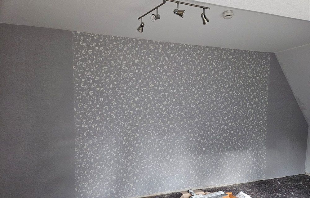 Ein Raum mit einer grauen Wand und einer Deckenleuchte.