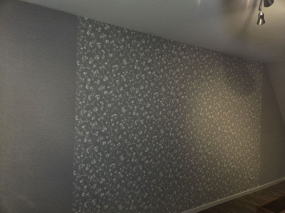 Eine Wand mit einem Muster und einer Lampe an der Decke.