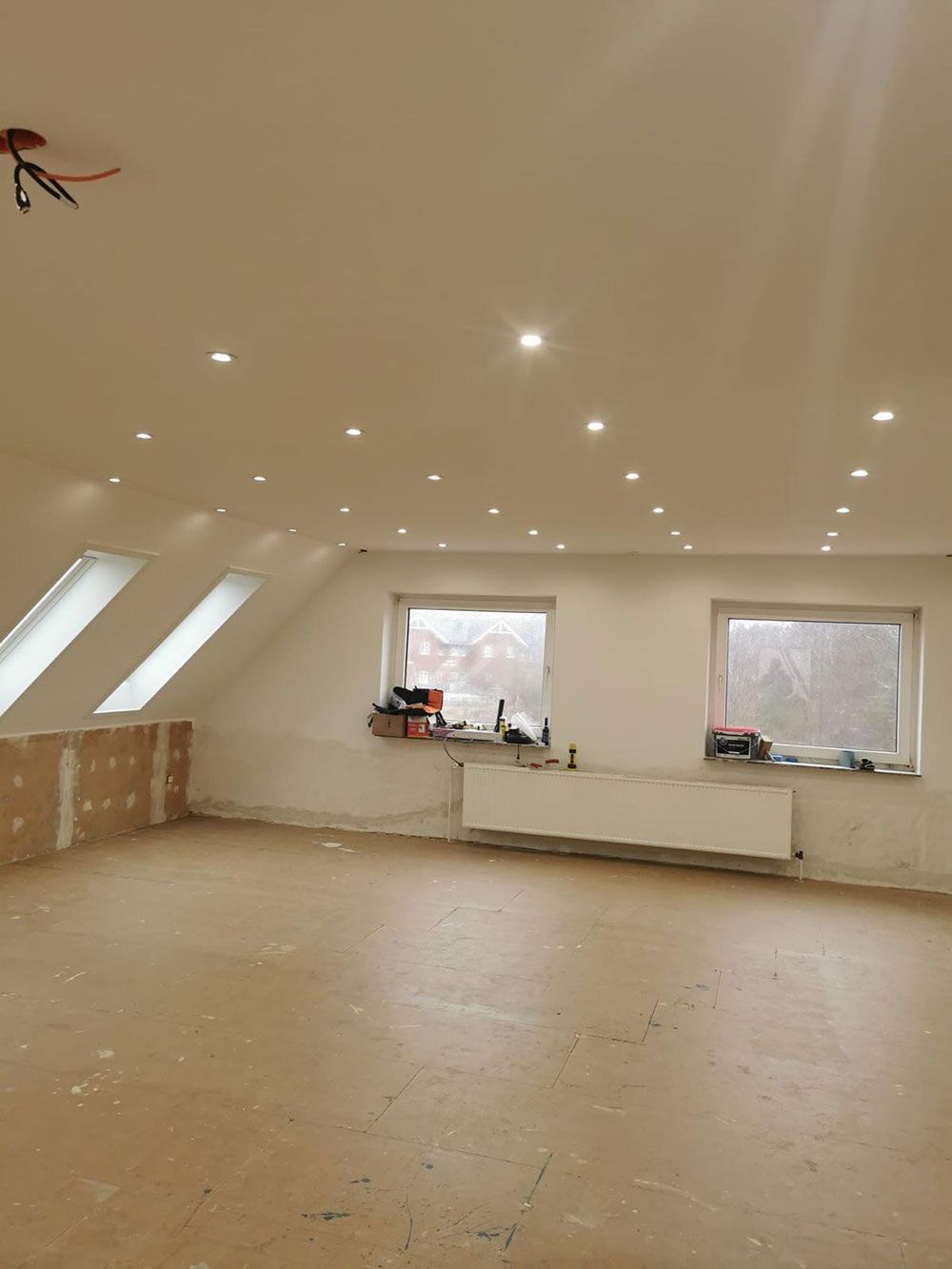 Ein leerer Raum mit einem Deckenventilator und einem Fenster.