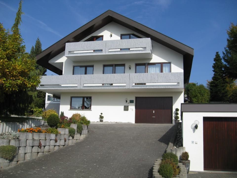 Malerbetrieb Blum GmbH & Co. KG, Haus mit Betonbalkon im ersten und zweiten Stock, grau gestrichen