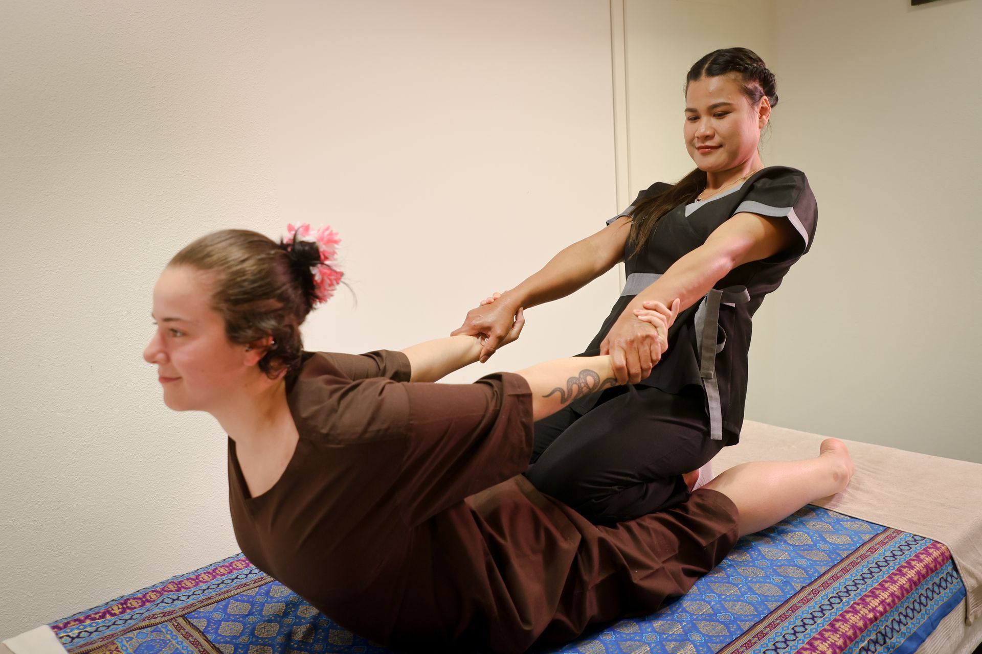 Femme recevant un massage du dos avec des compresses d'herbes.