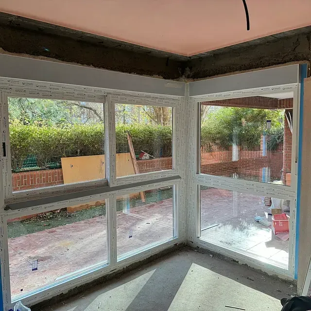 Una habitación con muchas ventanas y una pared de ladrillos.