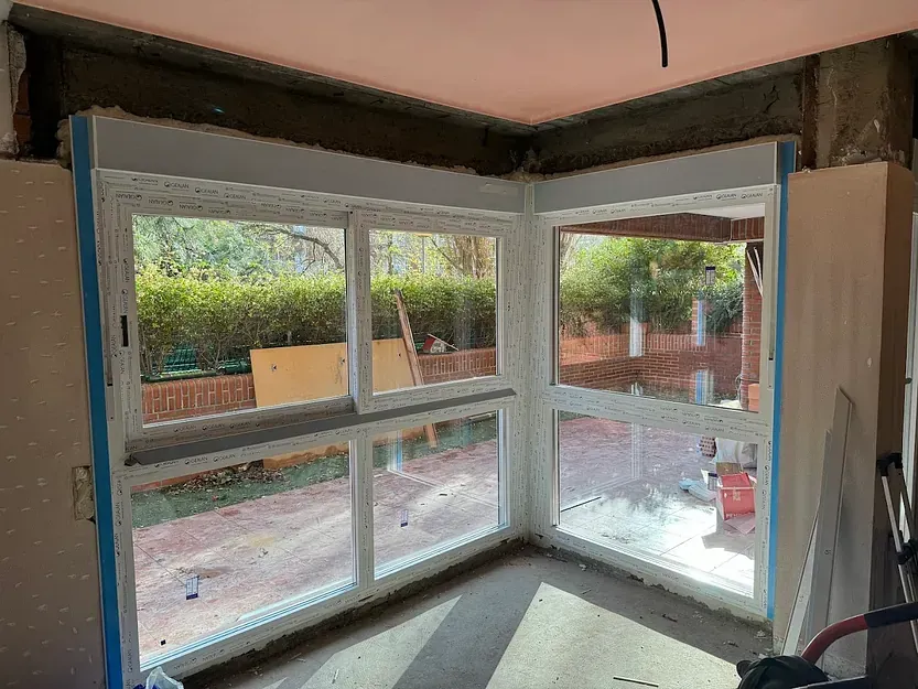 Una habitación con muchas ventanas y una pared de ladrillos.