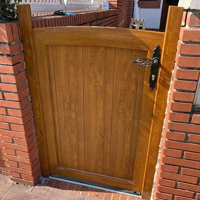 Una puerta de madera está unida a una pared de ladrillos.