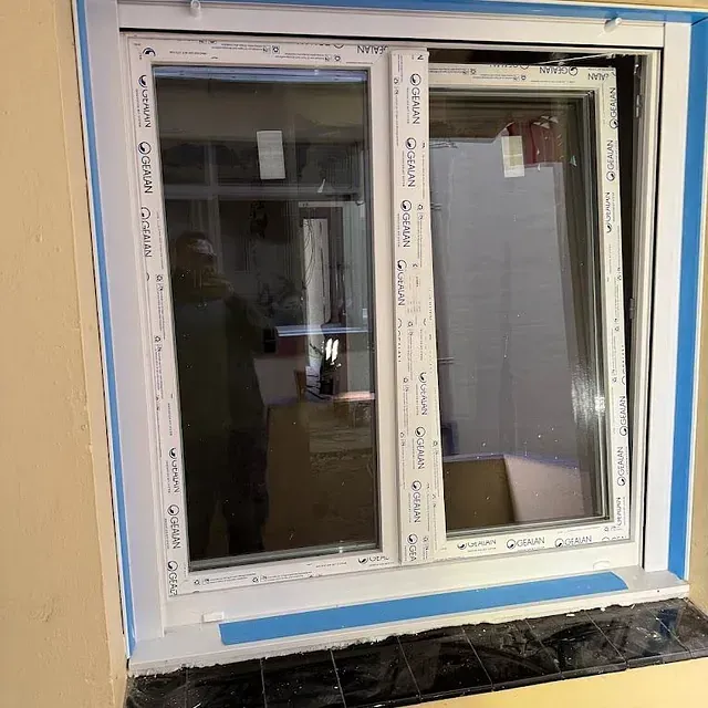 Se está instalando una ventana en una pared de una casa.