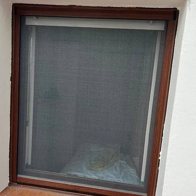 Una ventana con una mampara y un marco de madera.