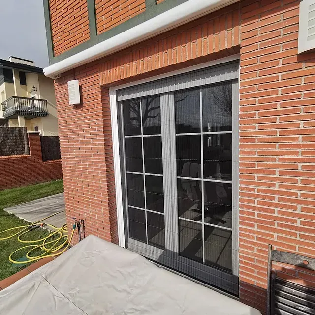 Una sala de estar con ventana, radiador y persianas blancas.