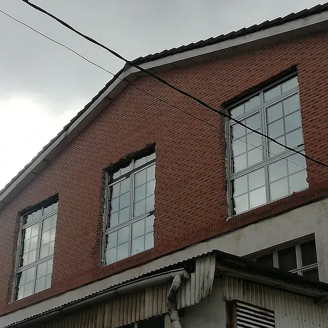 Un edificio de ladrillo con muchas ventanas contra un cielo nublado.
