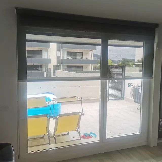 Una sala de estar con una puerta corrediza de vidrio que conduce a un balcón.