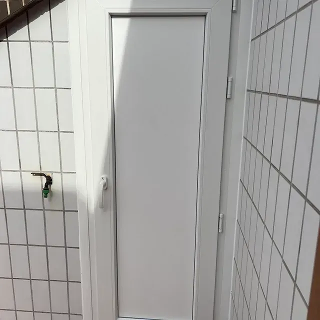 Una puerta blanca con una manguera verde conectada a ella.