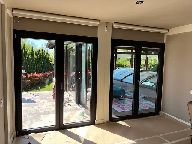 Una habitación con muchas ventanas y un coche al fondo.