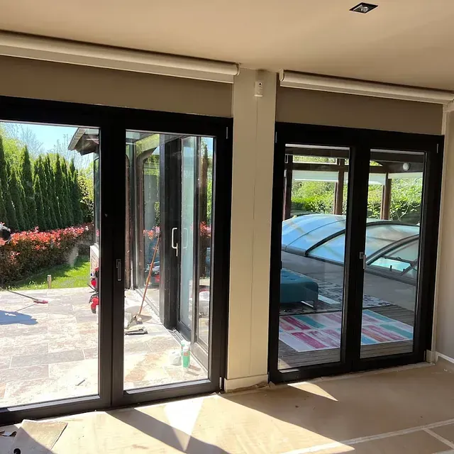 Una habitación con muchas ventanas y un coche al fondo.