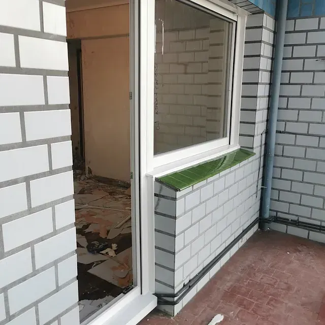 Un edificio de ladrillo blanco con una gran ventana.