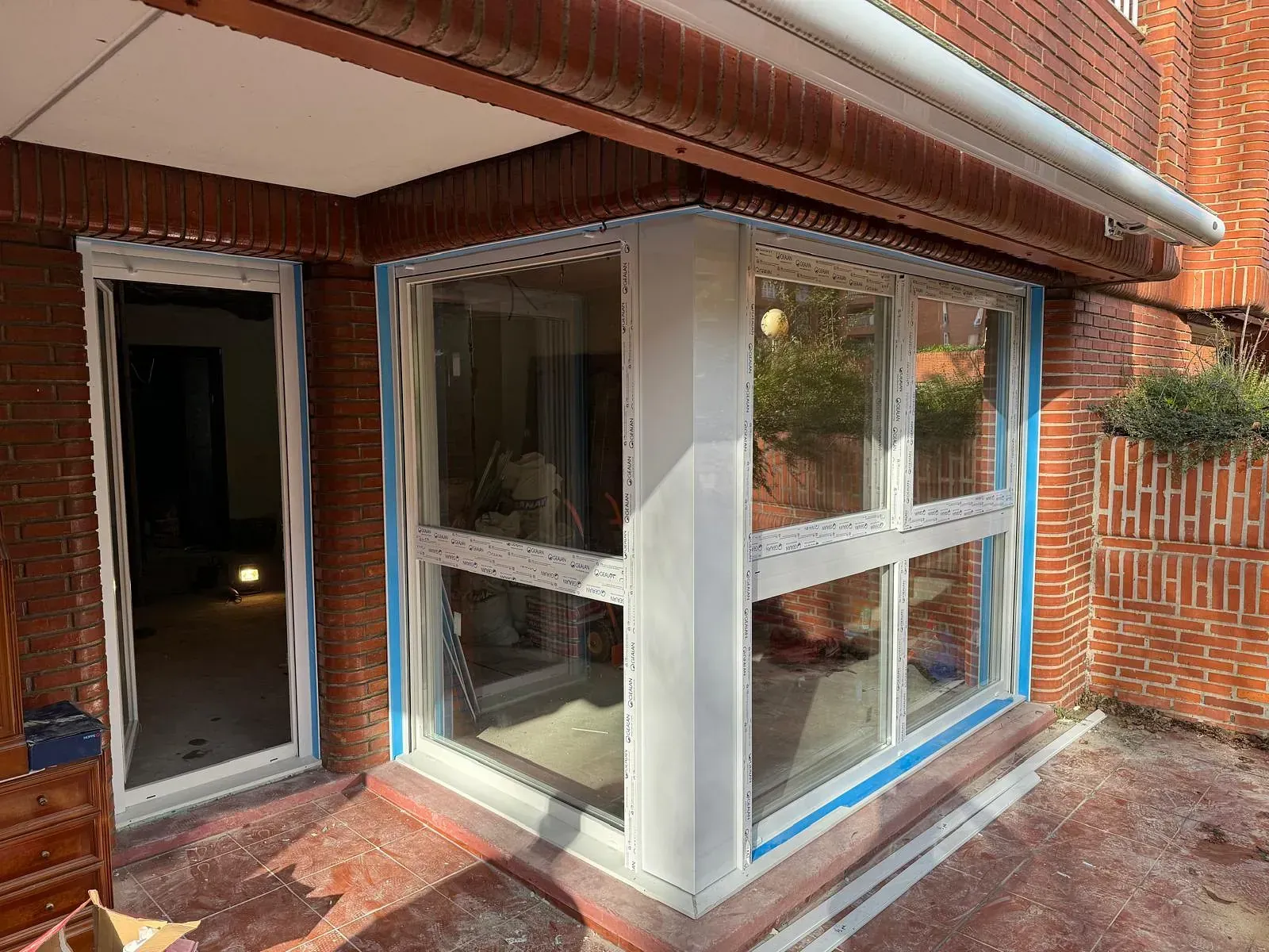 Un edificio de ladrillo con muchas ventanas y un toldo blanco.