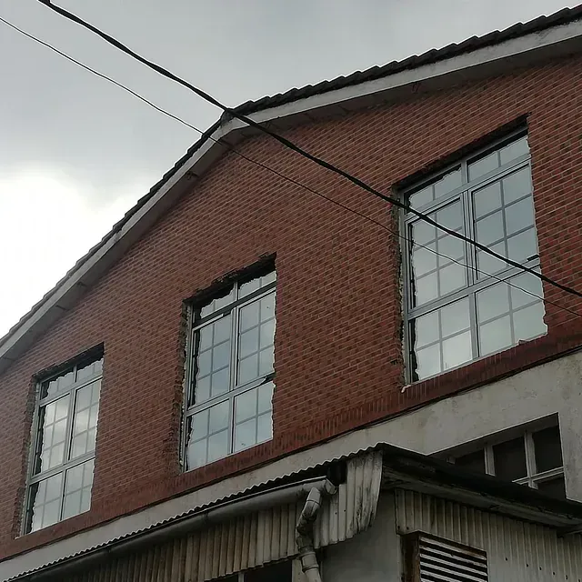 Un edificio de ladrillo con muchas ventanas en un día nublado.