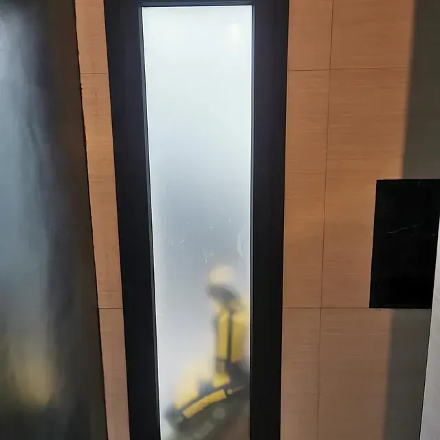 Una puerta con el reflejo de una persona en ella.